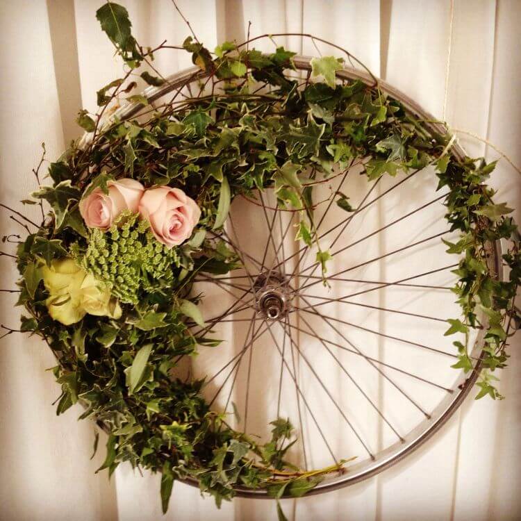 Літній декор: композиція з квітів на основі з велосипедного колеса