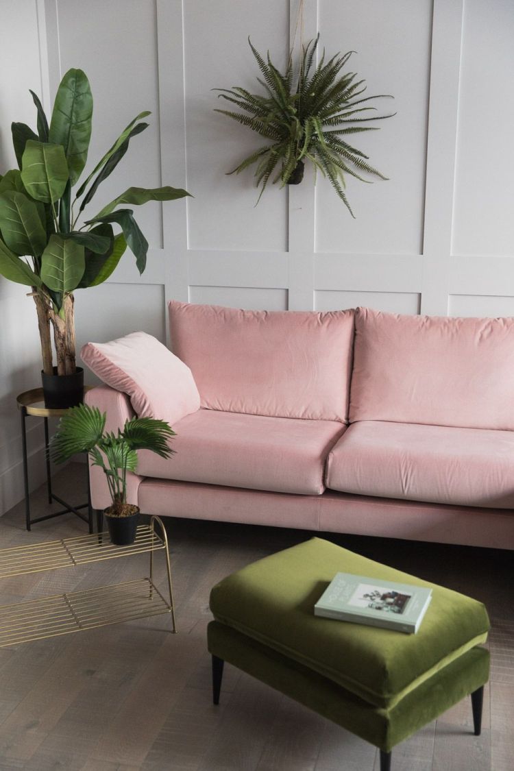 Блідо-рожева оббивка дивана чудово поєднується зі світлими стінами та зеленими рослинами