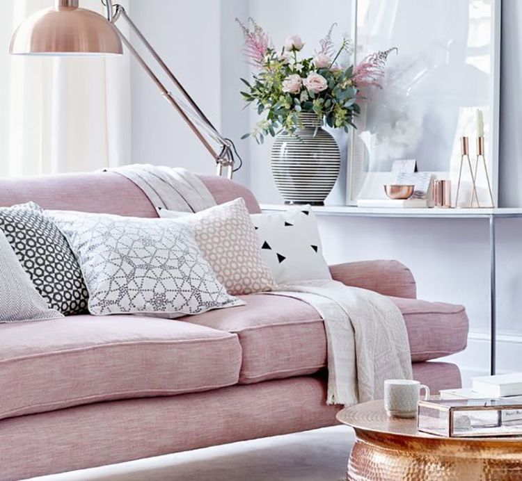 Блідо-рожевий диван у вітальні  чудово поєднується із золотистими аксесуарами