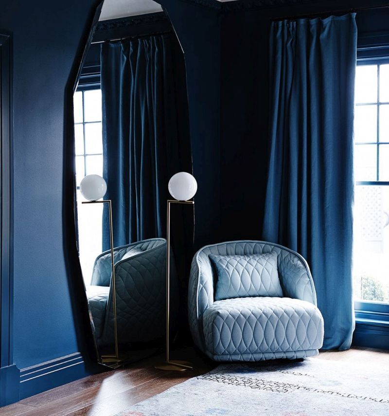 Синій колір стін у вітальні органічно доповнюють штори з тієї ж палітри