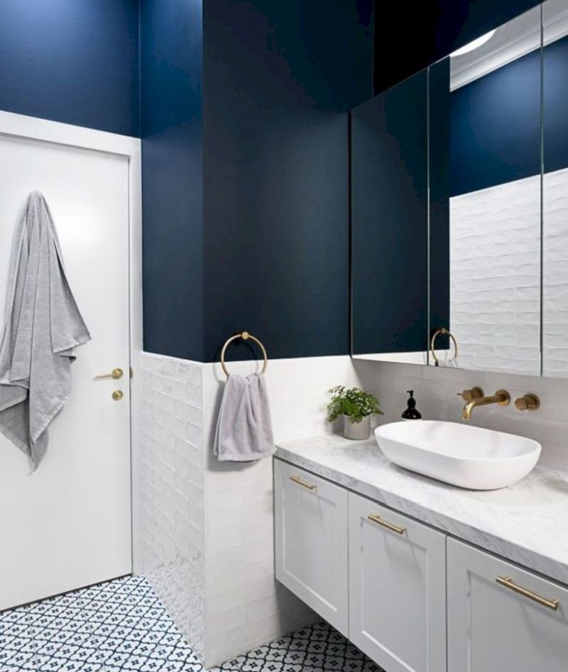 Пофарбовані сині стіни у ванній кімнаті у поєднання з білими кахлями та меблями