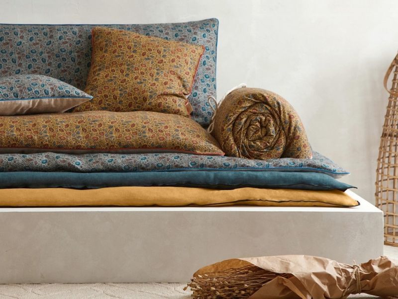 Складені красиві ковдри на дивані додають йому стильності