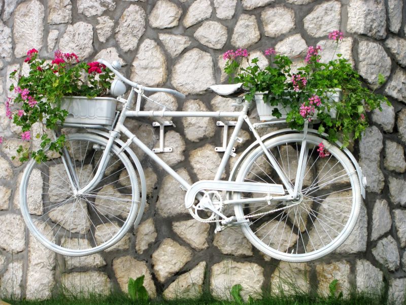 Клумба-велосипед, закріплений на кам'яній стіні