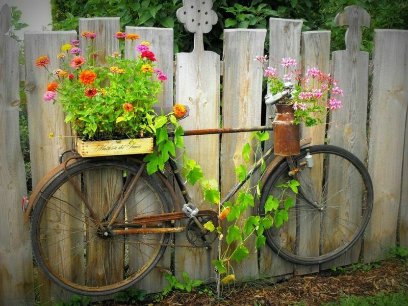 Клумба-велосипед, закріплена на паркані
