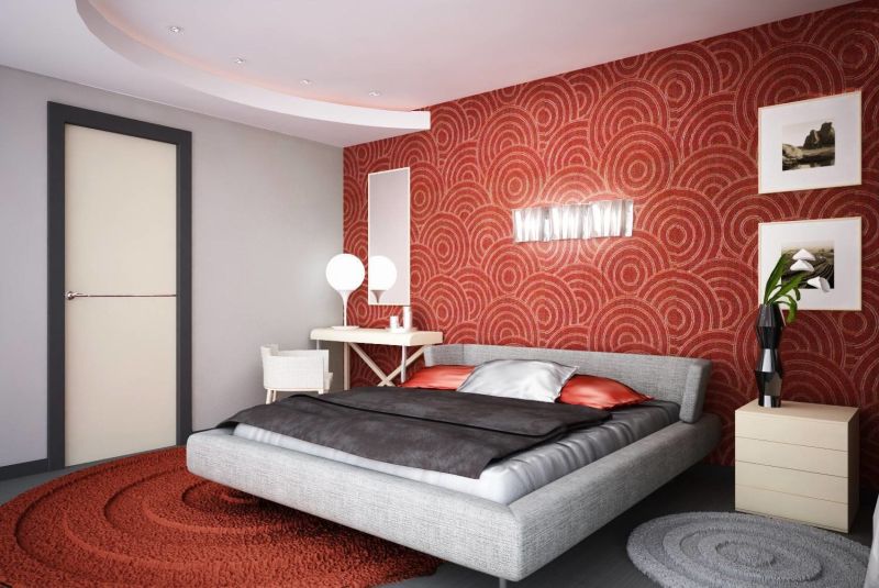 Акцентна стіна та килим червоного кольору гармонійно поєднуються з нейтральною основною палітрою інтер'єру спальні