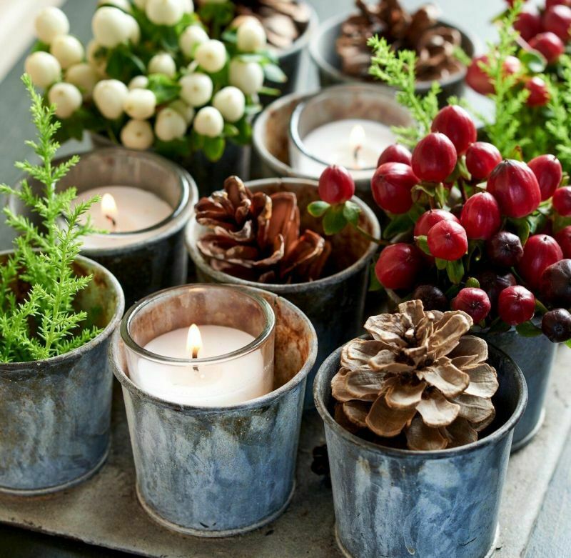 В новорічній композиції використані шишки, свічки та ягоди